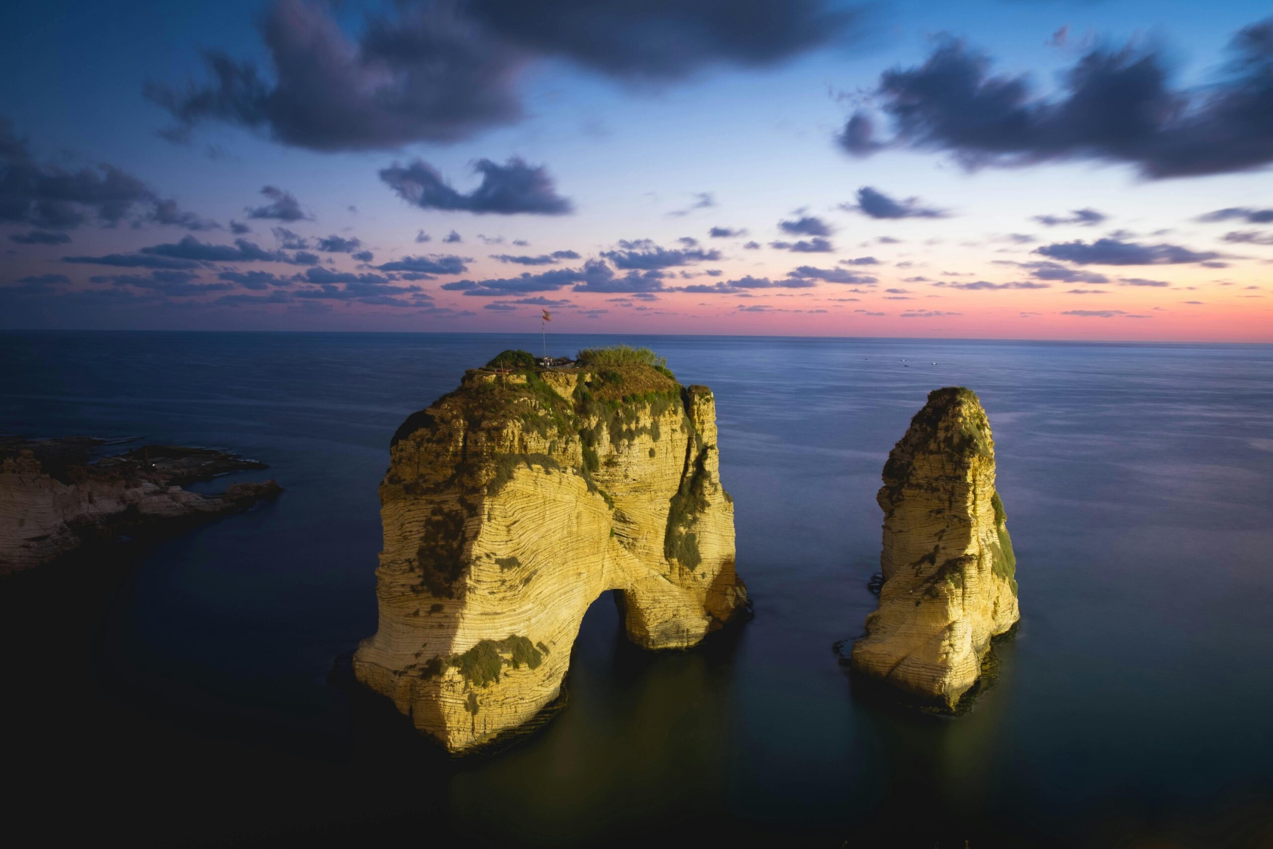 A breathtaking view of Pigeon Rock in Beirut during sunset, showcasing natural beauty and vibrant colors.